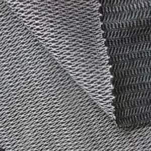 May include: Close-up of a textured fabric sample. The fabric is a combination of black and white threads woven in a diagonal pattern, creating a wavy, textured surface. The edges of the fabric are visible.