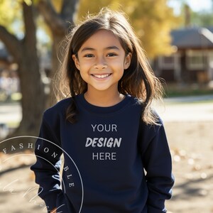 Peut inclure: Un jeune portant un sweat-shirt bleu marine avec le texte "YOUR DESIGN HERE" imprimé sur le devant. Le sweat-shirt est une toile vierge pour la personnalisation.