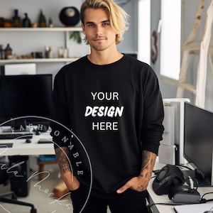 Puede incluir: Una sudadera negra de manga larga con el texto "YOUR DESIGN HERE" impreso en blanco en la parte delantera.