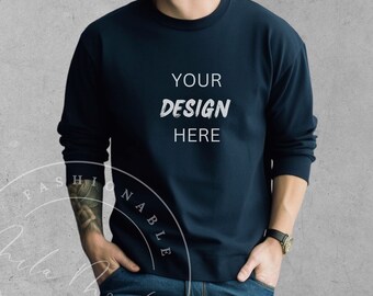 May include: A navy blue long-sleeved sweatshirt with the text "YOUR DESIGN HERE" printed on the front.