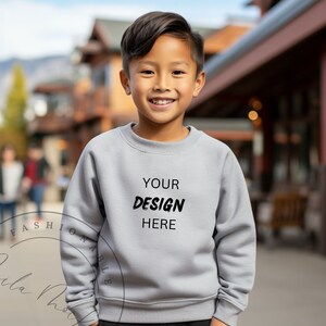 Può includere: Una felpa grigia con la scritta "YOUR DESIGN HERE" stampata sul davanti.