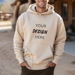 May include: A beige hoodie with a large pocket on the front. The hoodie has the text "YOUR DESIGN HERE" printed on the front.