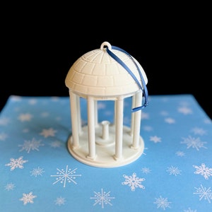 The larger UNC Old Well ornament, shown in detail against a Carolina Blue background.
