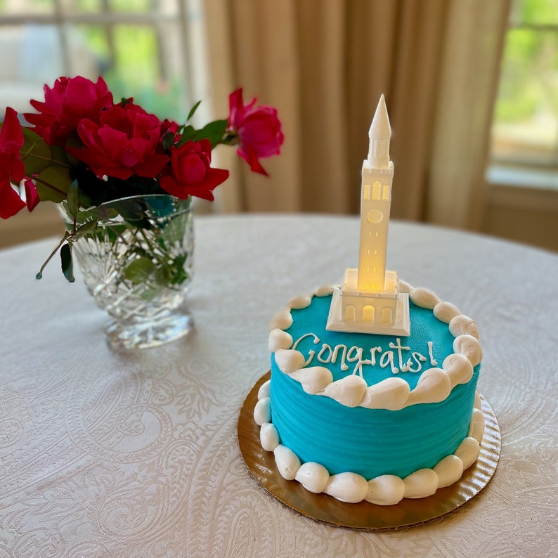 The UNC graduation party decoration, shown used as a cake topper.