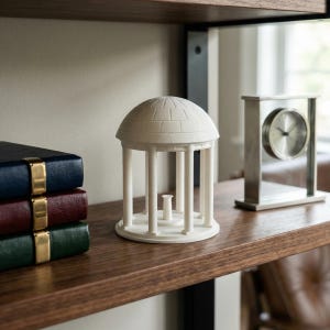 The UNC figurine used as office decor and designed as the Old Well on campus.