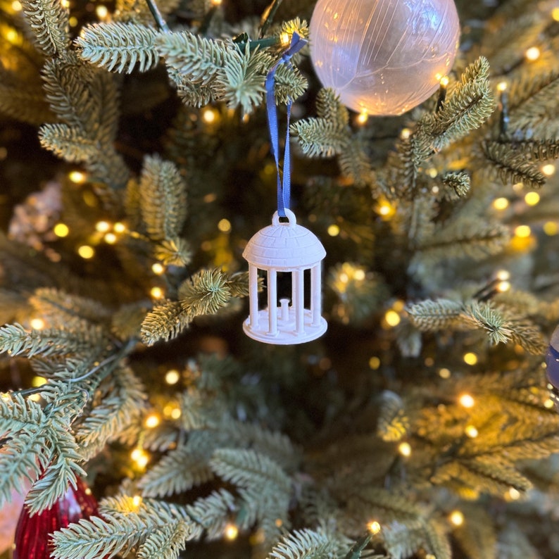 The UNC Old Well ornament, shown on a Christmas tree decorated for the holidays.