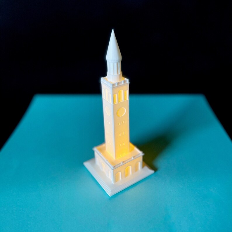 The lighted UNC Chapel Hill figurine, shown against a Carolina Blue background.