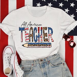 May include: White t-shirt with a red, white, and blue American flag design and the text "All American Teacher" with a pencil graphic. The shirt is on a red, white, and blue American flag background.