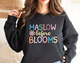 May include: Black sweatshirt with the text "MASLOW *before* BLOOMS" in colorful letters with a flower graphic.