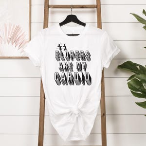 May include: White t-shirt with black text that reads "ElopErs Are My CaRdIo" in a 3D style font. The text is centered on the shirt.