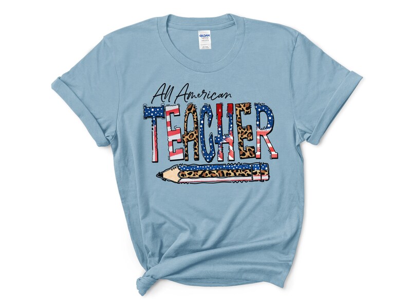 May include: Light blue t-shirt with the text "All American Teacher" in black lettering with a red, white, and blue American flag design and leopard print accents. The text is surrounded by a pencil with a leopard print design.