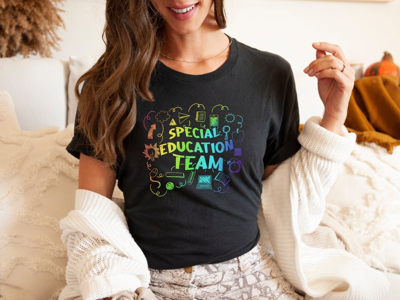 May include: A black t-shirt with a rainbow graphic that says "Special Education Team" surrounded by school-themed doodles.