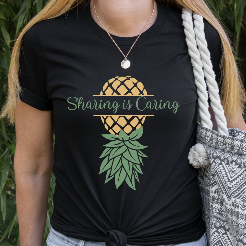 Puede incluir: Camiseta negra con un gr&aacute;fico de pi&ntilde;a y el texto "Sharing is Caring".