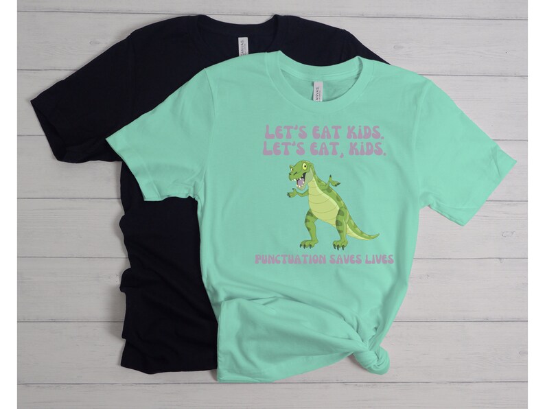 May include: A turquoise t-shirt with a green dinosaur graphic and the text "Let's eat kids. Let's eat, kids. Punctuation saves lives."