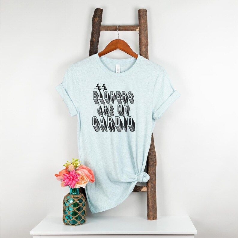 May include: A light blue t-shirt with the text "ELOPERS ARE MY CARDIO" in black, with a graphic of two stick figures running.