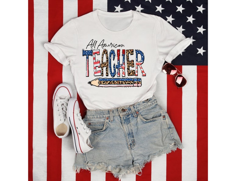May include: White t-shirt with a red, white, and blue American flag design and the text "All American Teacher" with a pencil graphic. The shirt is on a red, white, and blue American flag background.