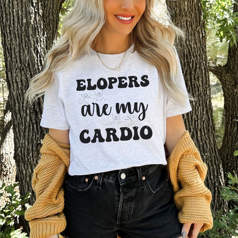 May include: A white t-shirt with black text that reads "Elopers are my cardio" with stick figure drawings of people running.