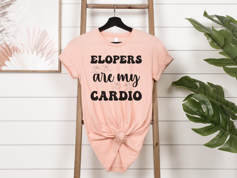 May include: A peach-colored t-shirt with black text that reads "ELOPERS are my CARDIO". The text is in a retro font style.