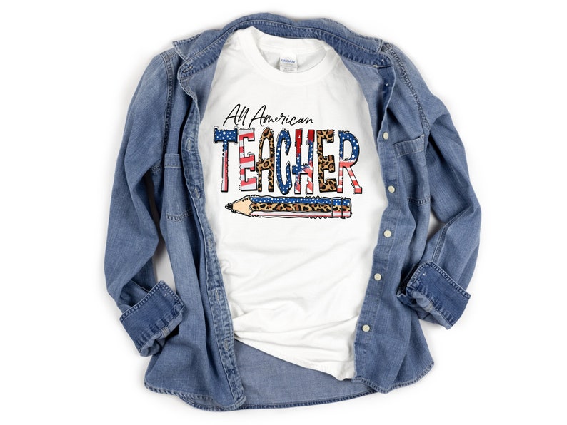 May include: White t-shirt with the text "All American TEACHER" in red, white, and blue with a leopard print and a pencil graphic.