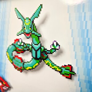 Puede incluir: Una criatura pixelada verde y amarilla con un cuello y una cola largos. La criatura est&aacute; en una pose de lucha con los brazos levantados. La criatura est&aacute; sobre un fondo blanco.