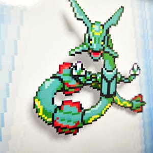 Puede incluir: Un personaje de Pokemon pixelado verde y rojo con un cuello y una cola largos. El personaje est&aacute; en una pose de lucha con los brazos y las piernas extendidos.