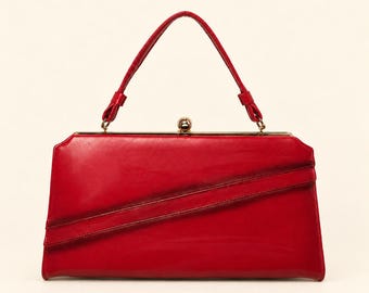 May include: A bright red handbag with a smooth, glossy finish, featuring a single top handle, a gold-toned metal frame, and a central kiss-lock closure. The front of the bag displays a distinct diagonal pleated detail across the body.