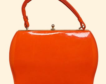 Bolsa vintage laranja de verniz com alça superior, estilo anos 1960, com acabamento brilhante.
