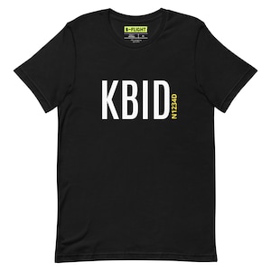 May include: Black t-shirt with white text that reads "KBID" and yellow text that reads "N1234D".