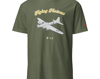 May include: Olive green t-shirt featuring a graphic of a B-17 bomber with the text "Flying Fortress" and "B-17" in a vintage style. The design is in shades of gray and yellow. The shirt has a classic crew neck.
