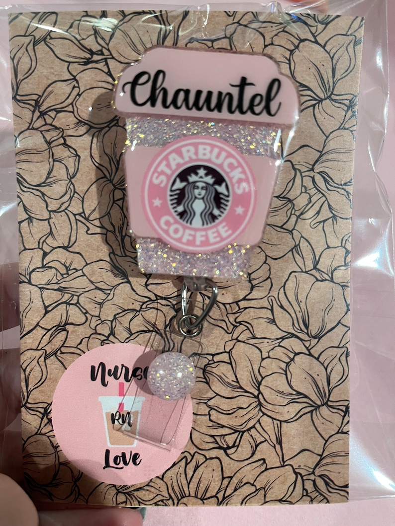 May include: Pink and white glitter Starbucks coffee cup with the name "Chauntel" on the top and a nurse badge holder with a pink and white glitter coffee cup with the text "Nurse Love" and a pink "RN" on it.