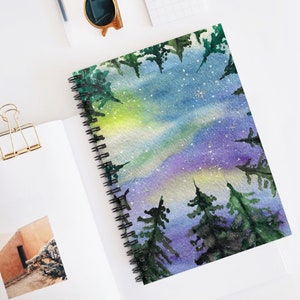 May include: A watercolor painting of a night sky with a vibrant aurora borealis and a scattering of stars. The sky is viewed from a forest, with the tops of the trees framing the scene.