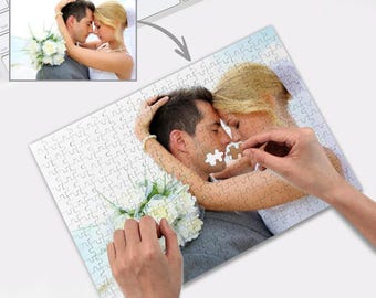 Peut inclure: Un puzzle blanc avec une photo d'un couple qui s'embrasse. Le couple est habillé en tenue de mariage et tient une pièce du puzzle ensemble.
