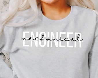 May include: A light gray sweatshirt with the text "mechanical ENGINEER" in white lettering. The sweatshirt is being worn by a person with long blonde hair. The text "color: ash" is visible in the bottom left corner of the image.