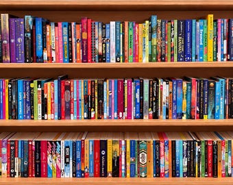 May include: A wooden bookshelf with three shelves filled with a large collection of books of various sizes and colors. The spines of the books display diverse titles, graphics, and text, arranged vertically in a dense, organized library display.