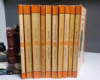 May include: A row of 12 Penguin paperback books with orange spines and a penguin logo. The titles include "Gigi", "Brideshead Revisited", "The Disenchanted", "Private Angelo", "Hurry On Down", "Tortilla Flat", "The Picture of Dorian Gray", "Black Mischief", "Room at the Top", and "The Thurber Carnival".