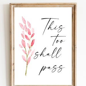 May include: A framed print with a watercolor illustration of pink flowers and the text "This too shall pass".