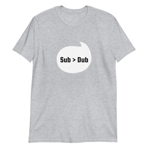 Puede incluir: Una camiseta gris jaspeada con una burbuja de di&aacute;logo blanca que dice "Sub > Dub" en texto negro.