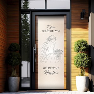 May include: A door with a decorative panel featuring a line drawing of a bride in a wedding dress, holding a bouquet. The panel has text in Turkish. The door is set in a wooden frame, with potted plants on either side.