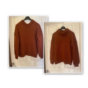 May include: Two brown knitted sweaters hanging on hangers. One sweater has a v-neck and the other has a turtleneck.