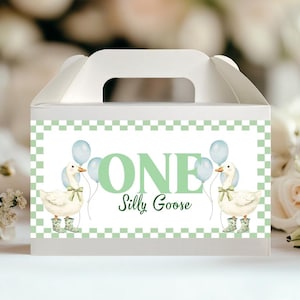 May include: White favor box with a handle, featuring a green and white checkered border. The box displays the text "ONE Silly Goose" with illustrations of geese holding balloons. The geese wear wellington boots.