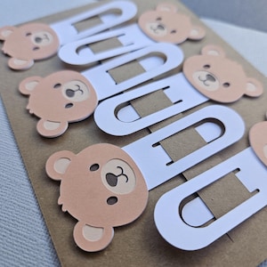 Close up of brown bear cardstock bookmarks clipped onto display packaging