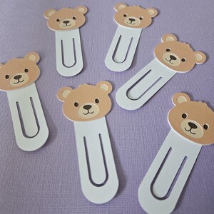 multiple brown bear bookmarks shown on purple page as background