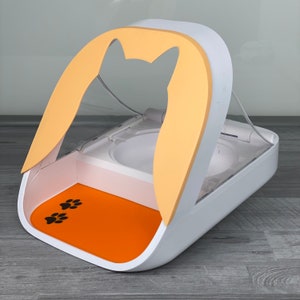 May include: White and orange automatic pet feeder with a clear lid and a paw print design on the orange mat. The feeder has a cat silhouette on the front.