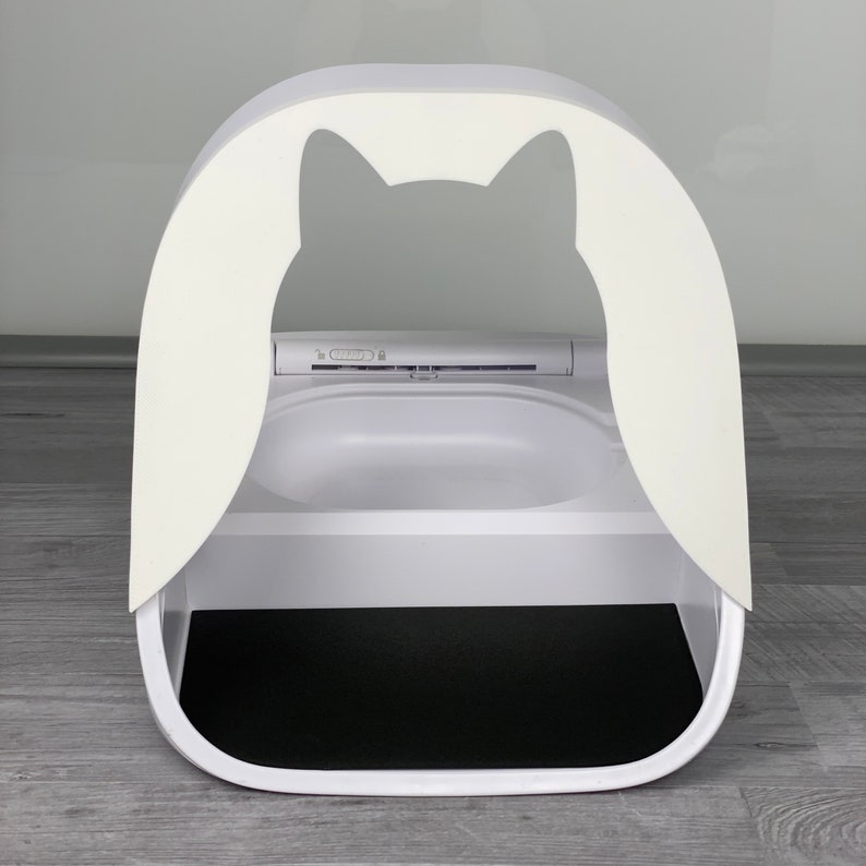 May include: White automatic self-cleaning cat litter box with a black litter tray and a cat-shaped opening.