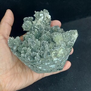 Handheld view of green chalcedony druzy calcite cluster for size comparison