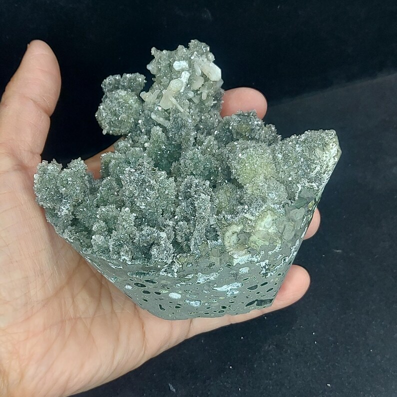 Handheld view of green chalcedony druzy calcite cluster for size comparison