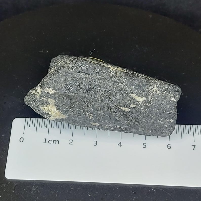 Natural black tourmaline stone close-up showing raw mineral structure