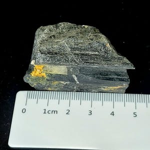 Natural black tourmaline rough specimen showing uneven surface and raw edges