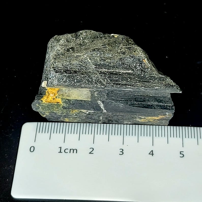 Natural black tourmaline rough specimen showing uneven surface and raw edges