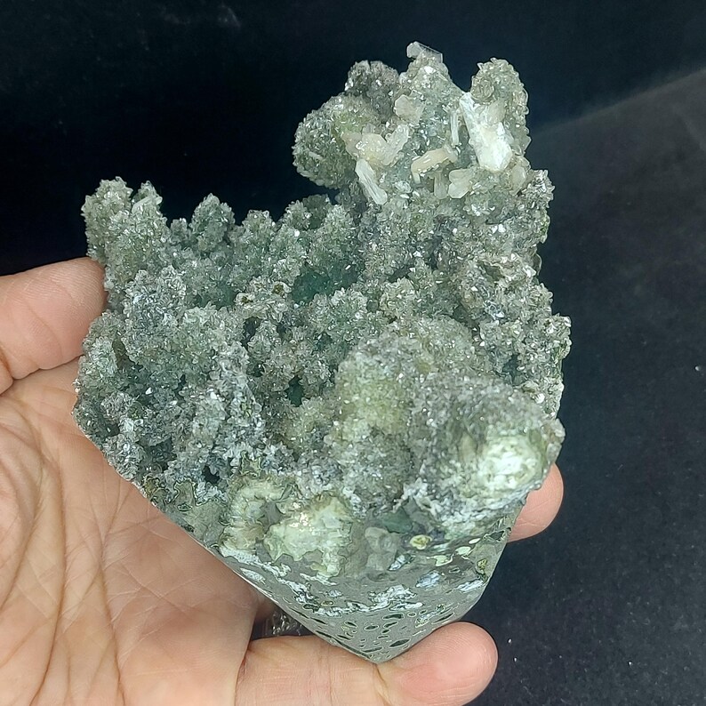 Handheld green chalcedony druzy calcite specimen showing size reference